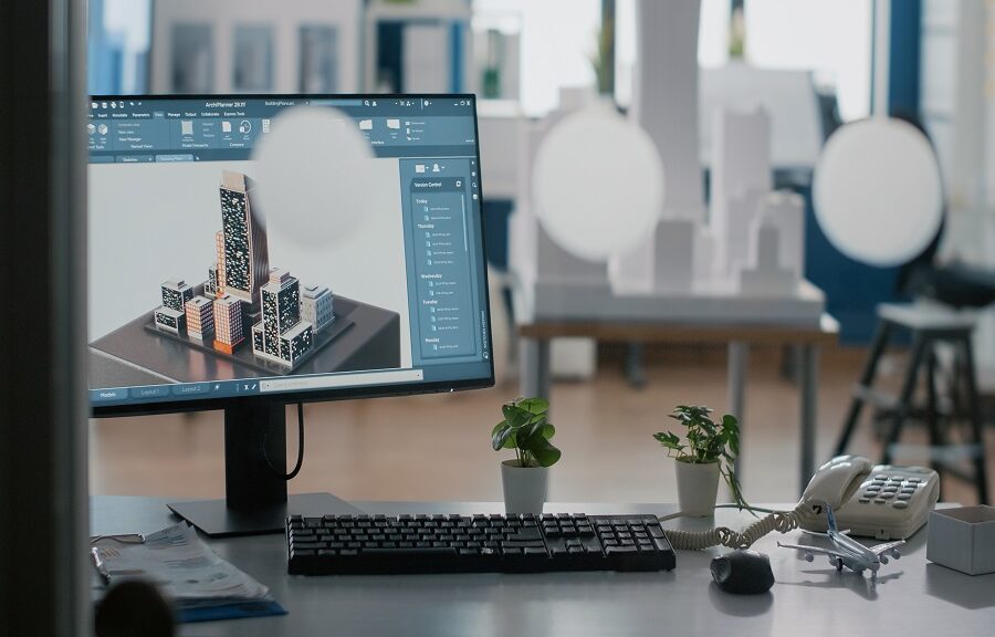 Close up of monitor with 3d building and construction layout on table in office. Urban real estate structure on computer to plan architectural development project. Graphic design
